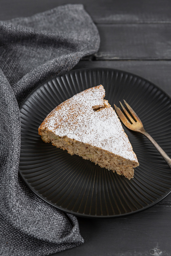 Ein Stück vom Rührkuchen liegt zusammen mit einer Kuchengabel auf einem Teller.