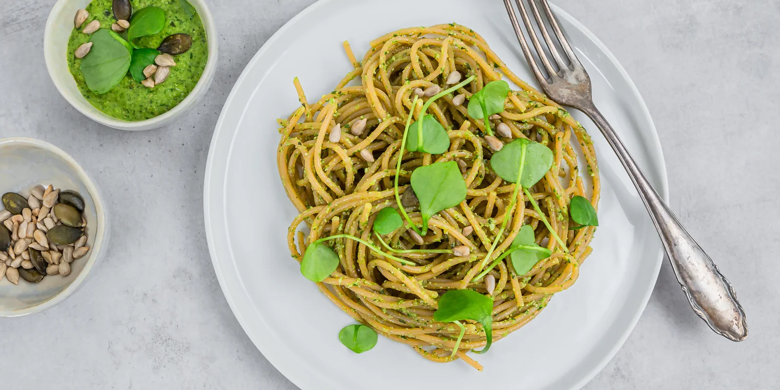 Teller mit Spaghetti aus roten Linsen mit Portulak-Pesto steht zum Essen bereit.