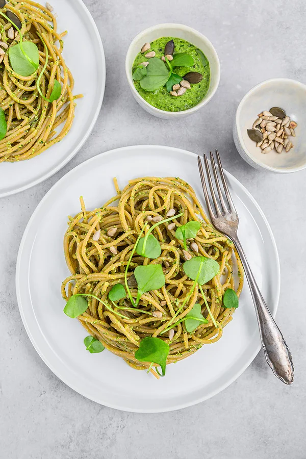 Teller mit Spaghetti aus roten Linsen mit Portulak-Pesto steht zum Essen bereit.