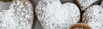 Mehrere fertige Vegane Schokoherzen mit Puderzucker bestreut nebeneinander